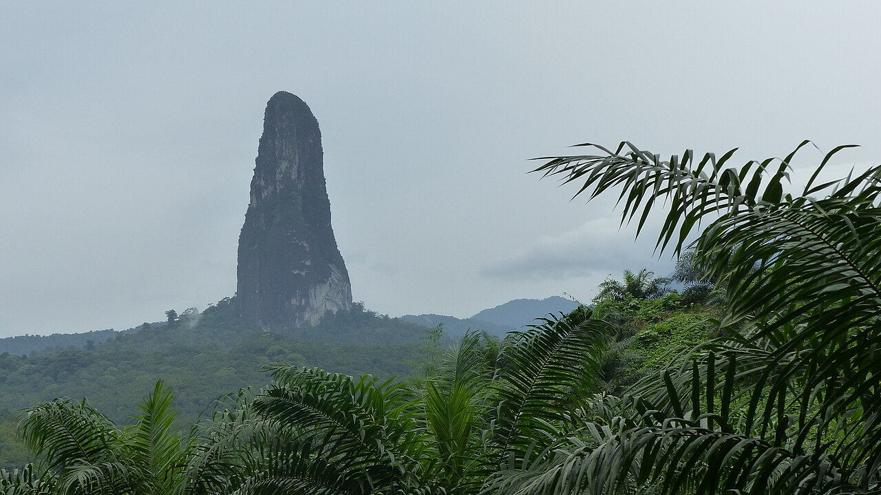 The steep peak of Pico Cão Grande rising above tropical vegetation on São Tomé