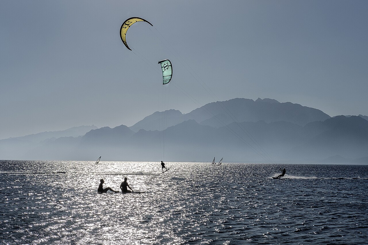 Kitesurfers on the Red Sea at Dahab, with mountains rising beyond the far shore