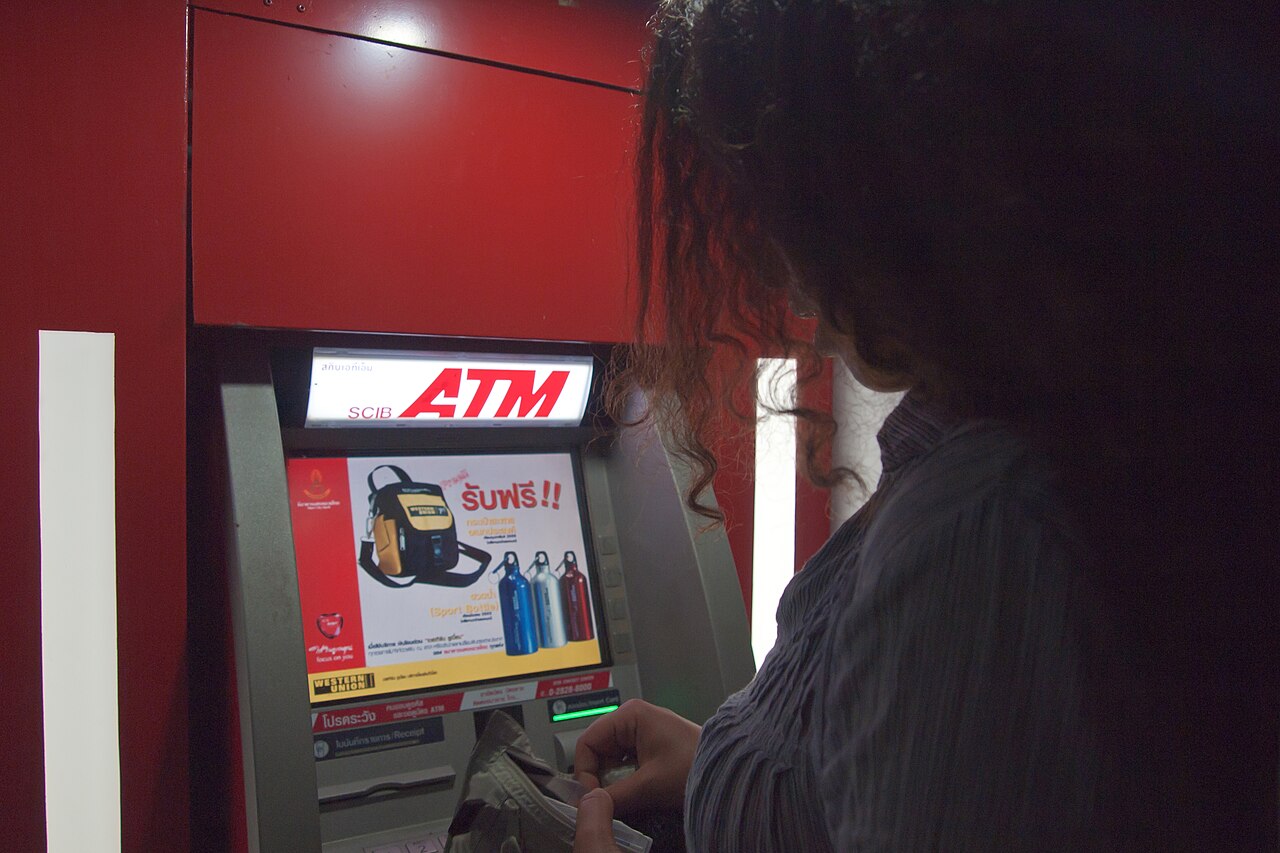 A person taking cash from a bank ATM on Koh Chang, Thailand