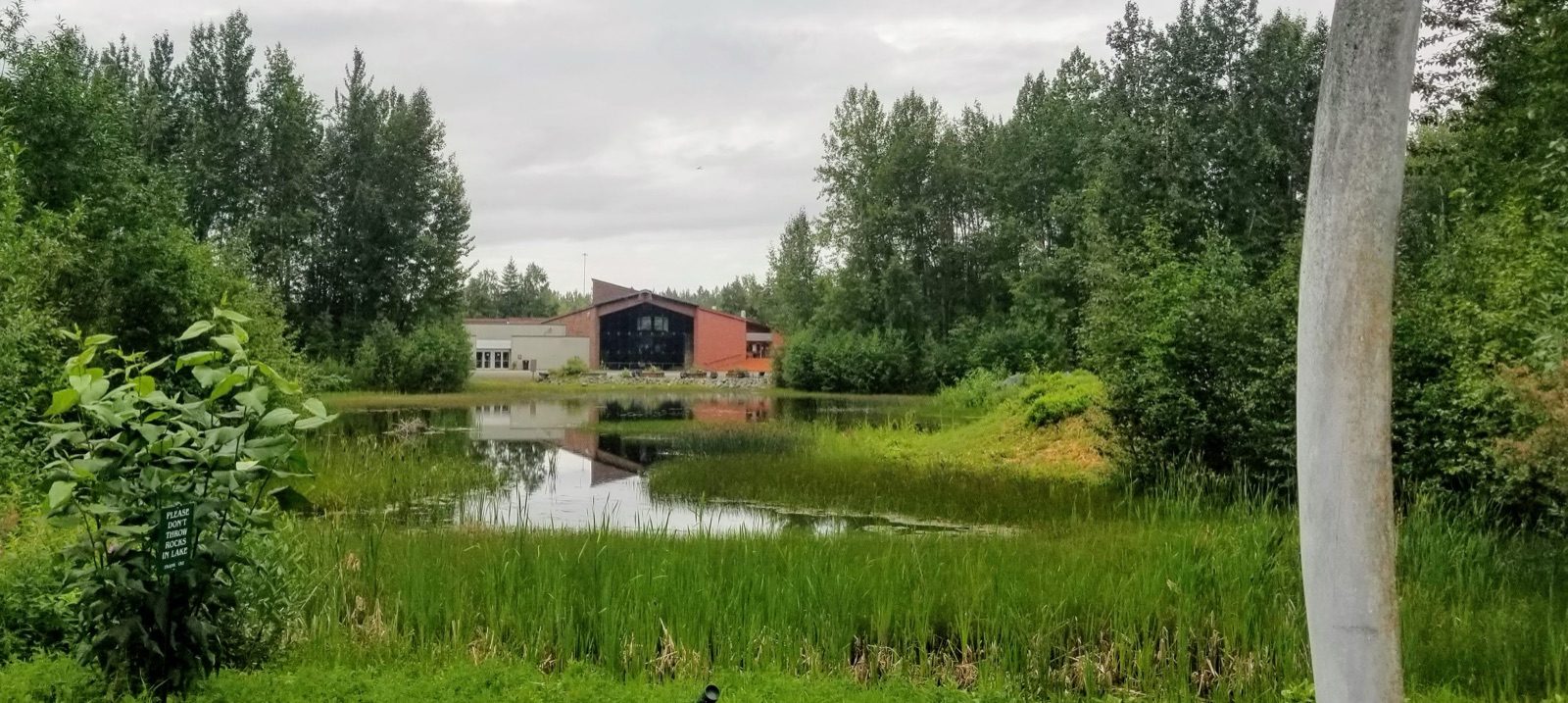 The Alaska Native Heritage Center seen across Lake Tiulana in Anchorage, with the windows of the Gathering Place visible