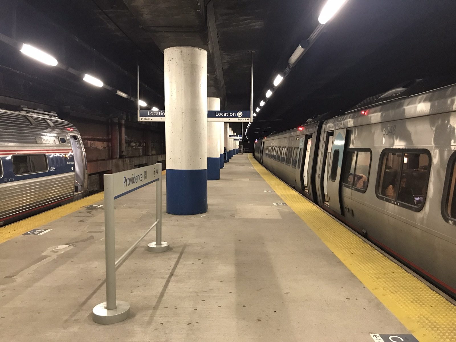 An Amtrak Acela train stopped at the platform at Providence Station, with a Northeast Regional train across the platform