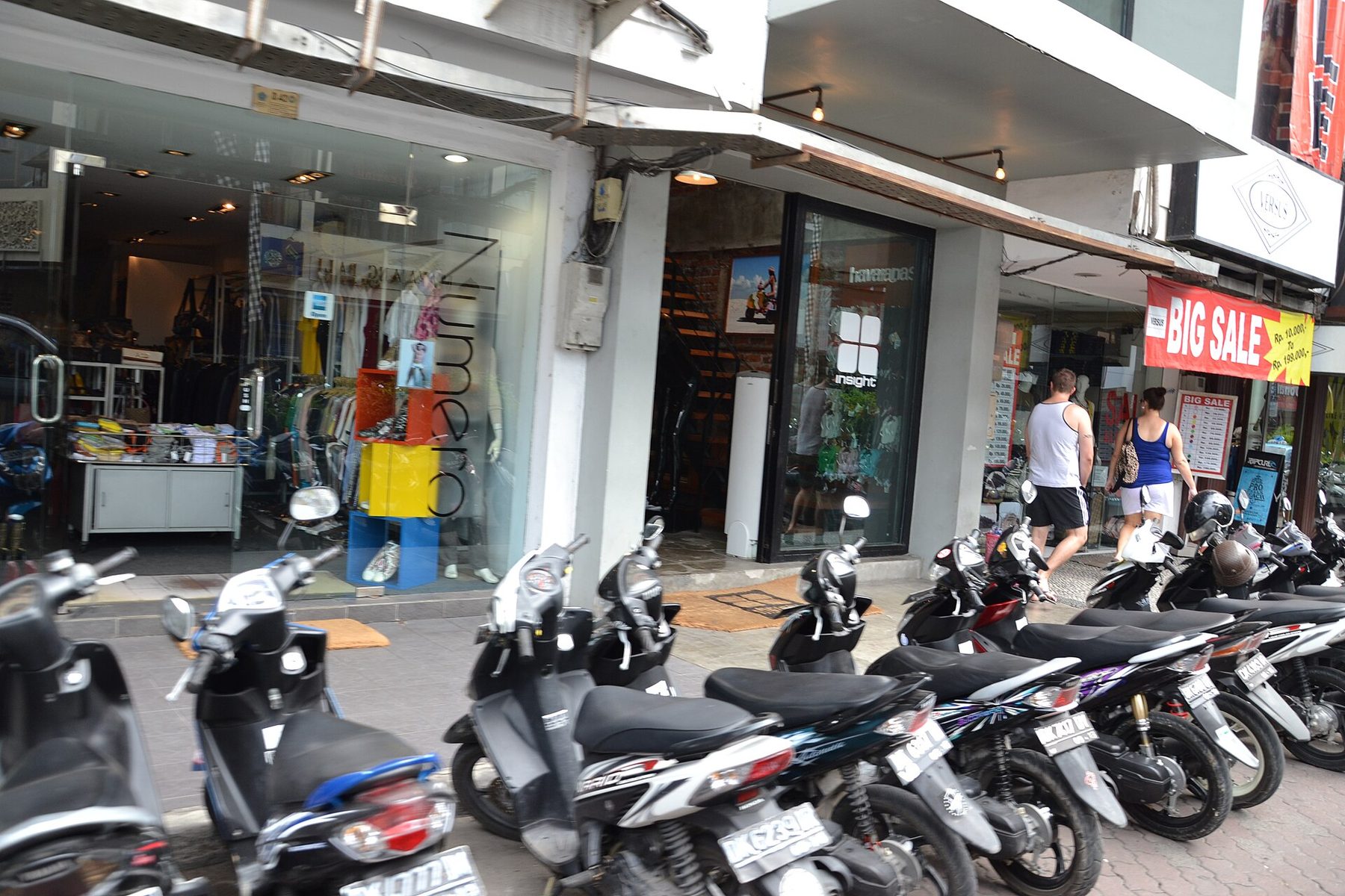 Rows of motorbikes parked tightly together in a paved lot at Kuta Square, Bali
