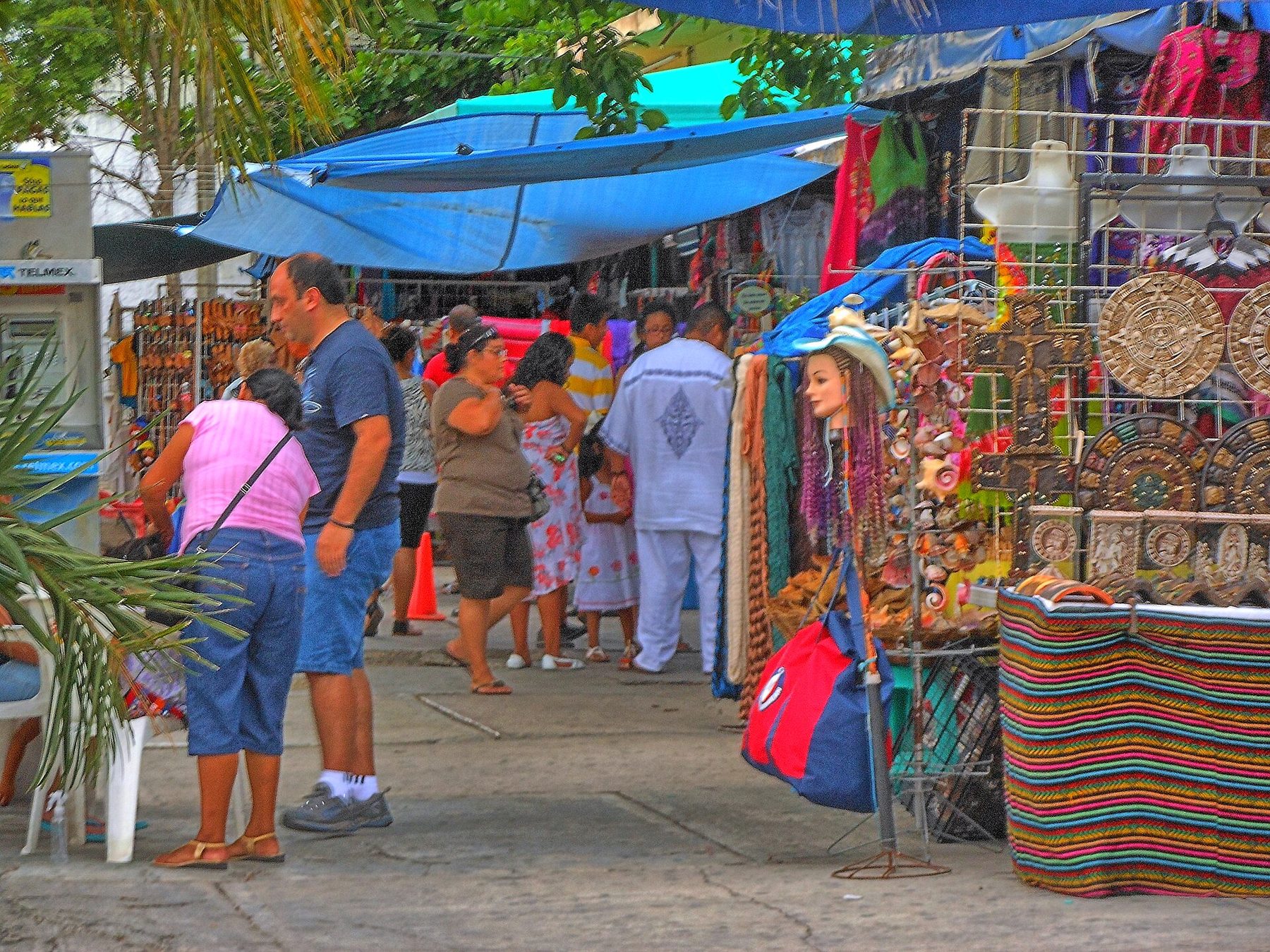 Open-air stalls hung with bright blankets, hats and souvenirs along a covered walkway at Mercado 28 in downtown Cancún.
