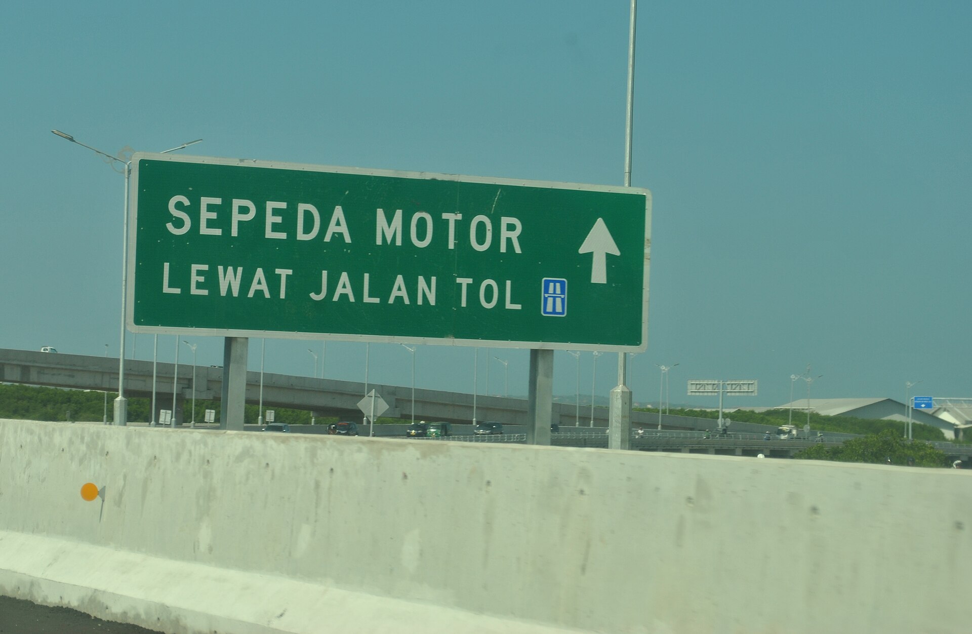 A road sign at the Benoa to Nusa Dua tollway entrance directing motorbikes into their own lane