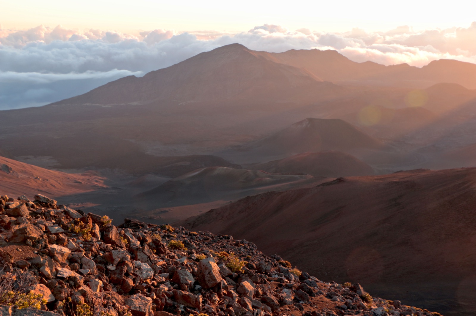 Early light fills the crater of Haleakalā on Maui, with clouds below the rim