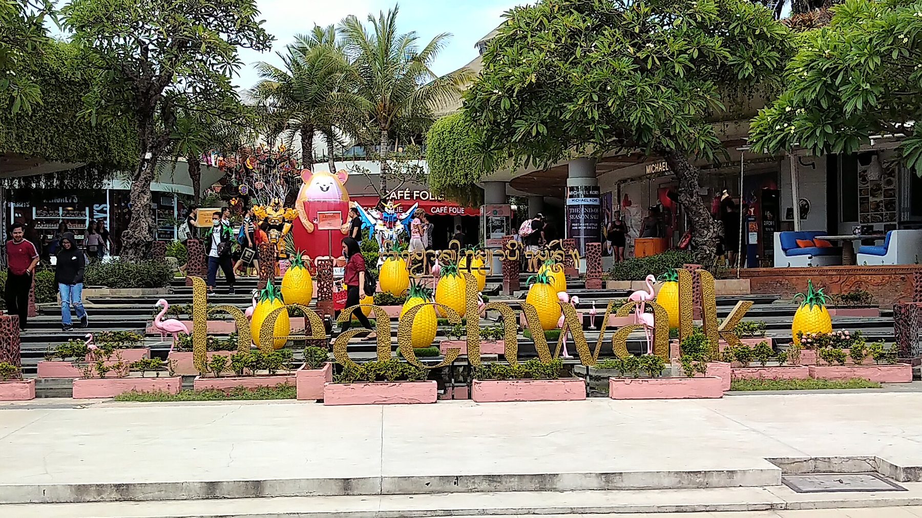 The Beachwalk shopping complex, a low tiered building with planting on its terraces, along the road at Kuta Beach