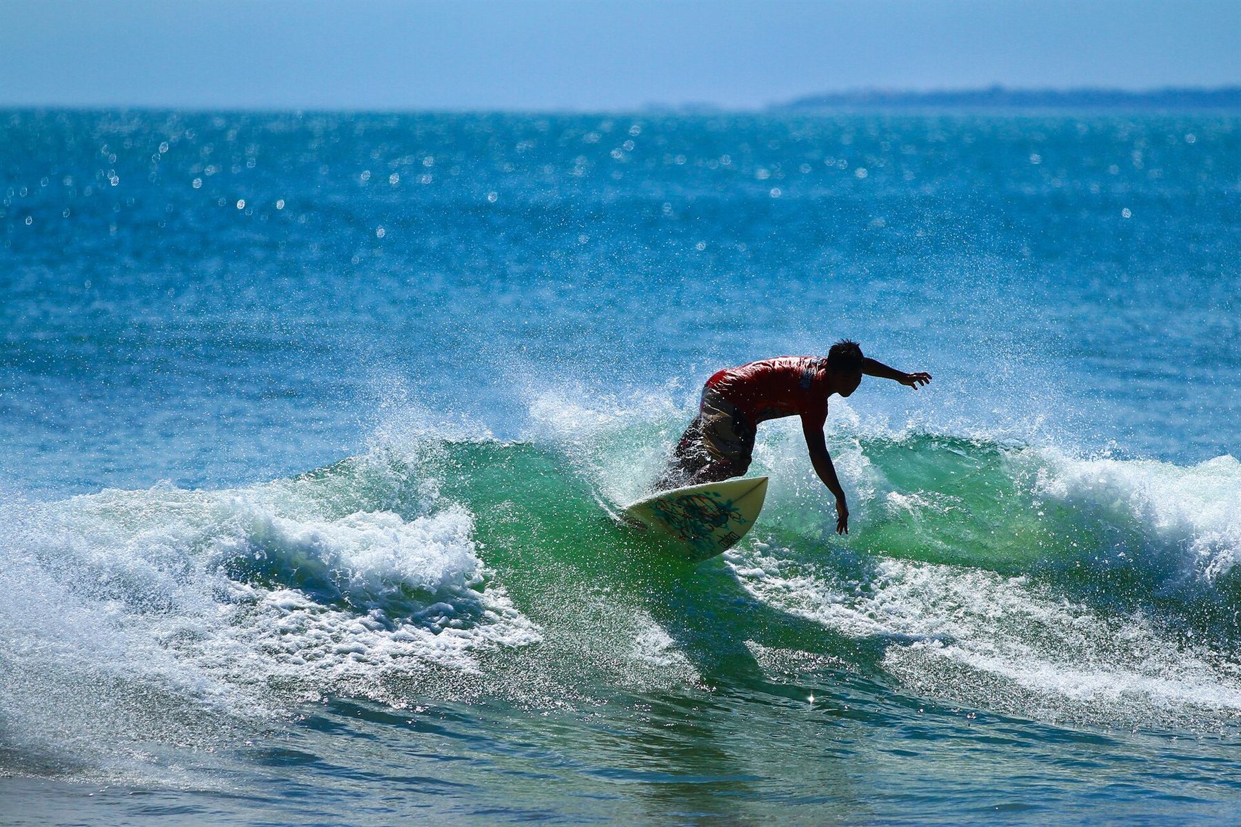 A surfer in the water at Kuta Beach, Bali