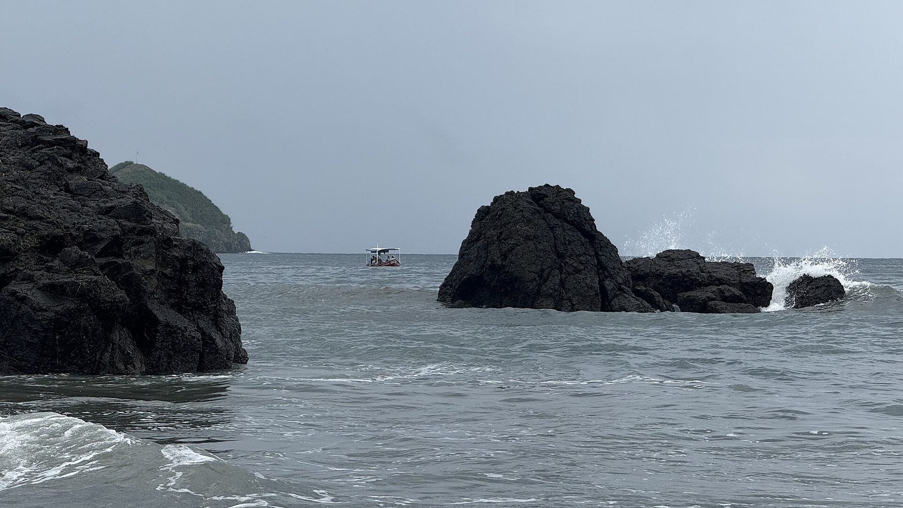 A curving sand beach backed by dense green forest at Manuel Antonio on Costa Rica's Pacific coast
