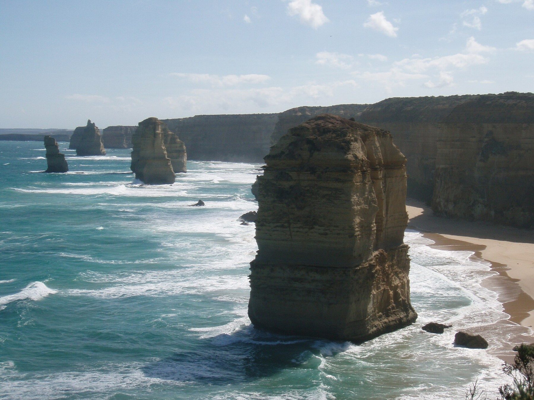 Sea stacks beside pale coastal cliffs and blue water at the Twelve Apostles