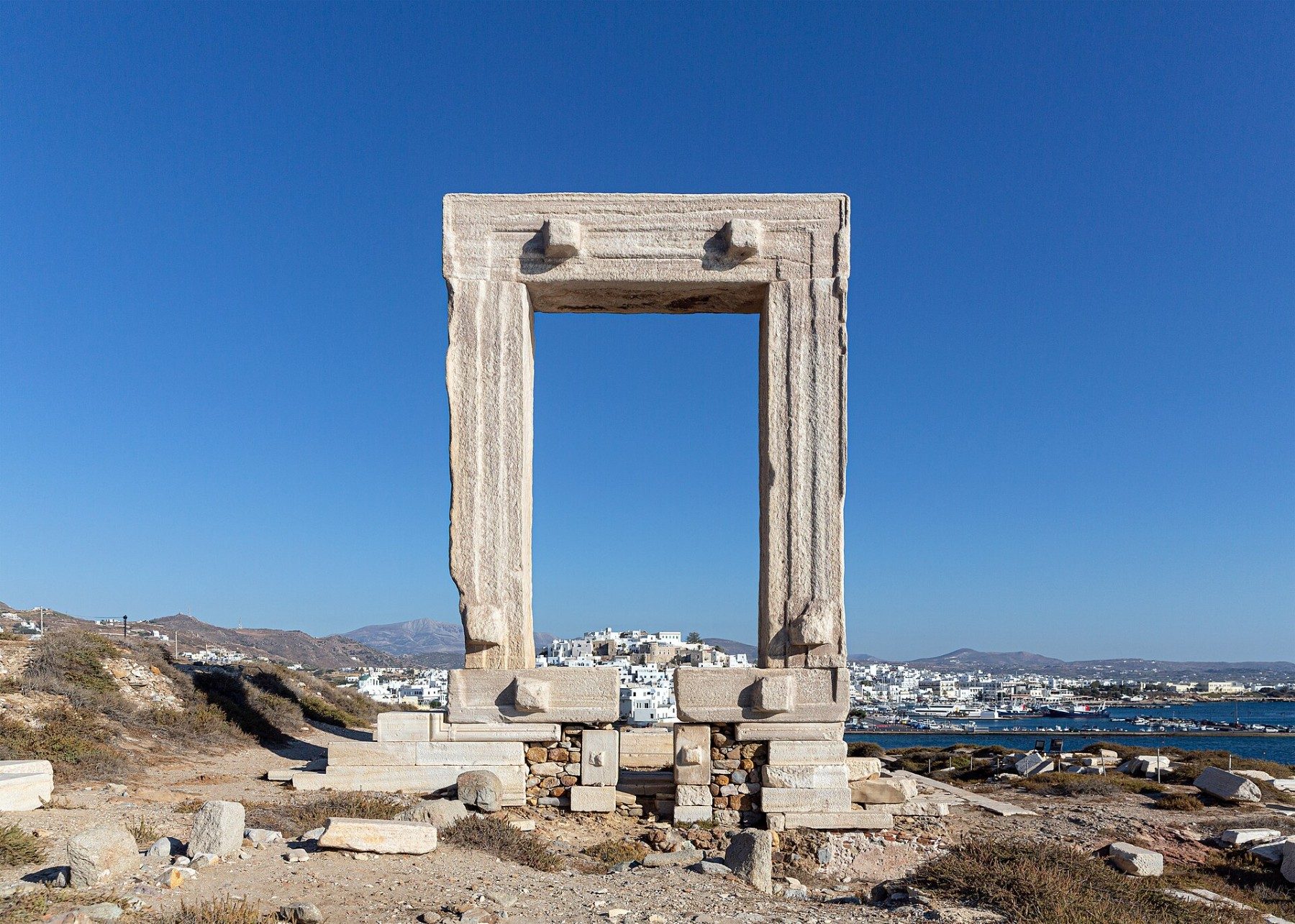 The marble Portara frames Chora and the port of Naxos across the water